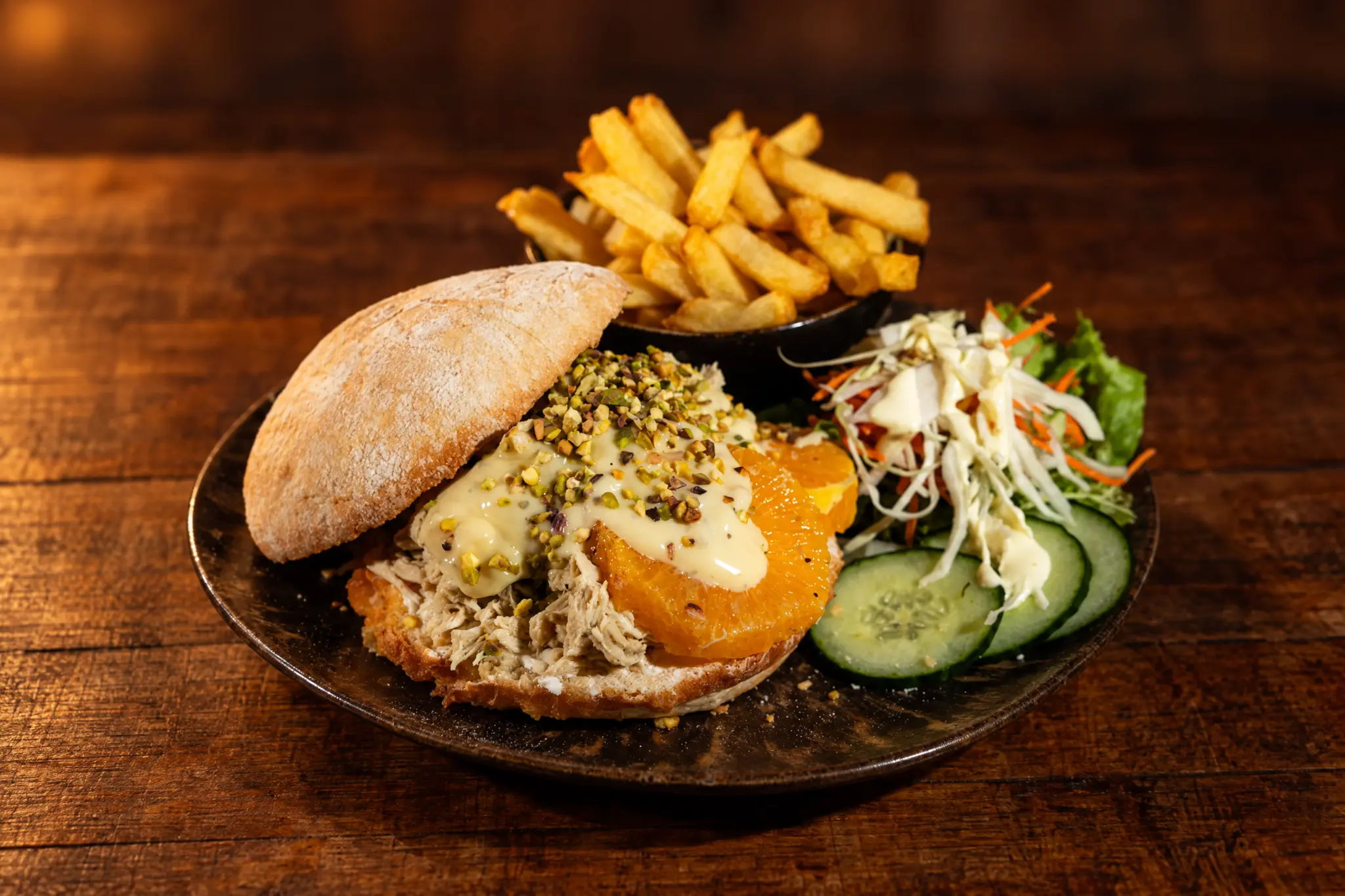 Burger Sorrento avec effiloché de poulet, orange grillée et pistaches.